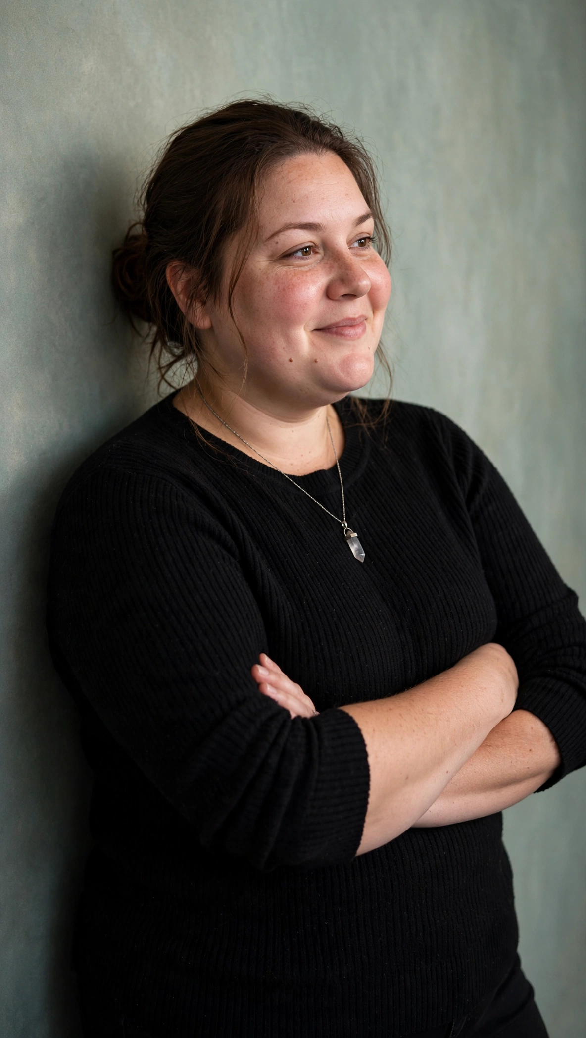 Echo in a relaxed three-quarter portrait against a sage studio wall
